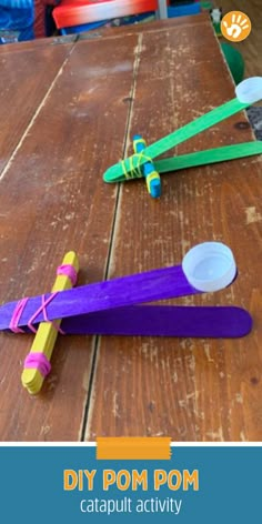 popsicle craft for kids to make with pom poms on top of a wooden table