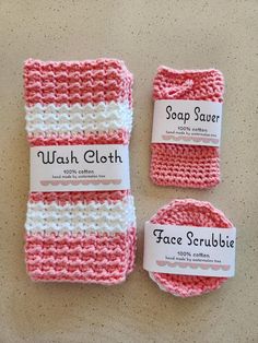 three pink and white crocheted washcloths with labels on them sitting next to each other