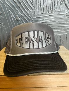 This Texas Bulge Foam Hat isn't messing around! It's ruggedly handsome in charcoal grey and black, with a handy rope detail to finish off the look. It'll fit like a glove, y'all! Texas Hats Women, Black Flat Bill Trucker Hat For Rodeo, Black Trucker Baseball Cap For Rodeo, Rodeo Snapback Trucker Hat, Fitted Caps, Dinosaur Print, Clothes Collection, Tee Shop, Fitted Hats