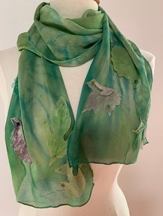 Dies ist ein handgemachter Seidenschal, der im Herbst fallende Blätter nachahmen soll.  Licht wie Luftseide Chiffon wird zuerst in Grüntönen mit der Shibori-Methode gefärbt, bei der Stofffalten und anschließend färben.  Die Enden des Schals sind dann mit flatternden "fallenden" Blättern verziert. Die Blätter werden aus den Appalachian-Wäldern von North Carolina gesammelt, dann gepresst und verwendet, um individuelle, gemalte, hoch detaillierte Seidenblatt-Drucke herzustellen.  Sie werden dann ge Elegant Green Summer Scarves, Handmade Bohemian Green Silk Scarf, Green Silk Shawl Scarf, Artistic Green Silk Scarf, Silk Scarf Design, Leaf Scarf, Silk Set, Fall Scarves, French Knots