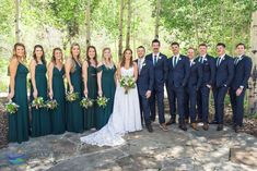 a group of people standing next to each other in front of trees and rocks with flowers