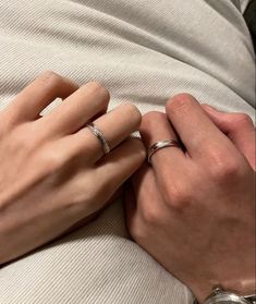 two hands holding each other while wearing wedding rings