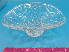 a clear glass bowl sitting next to a ruler