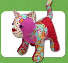 a colorful stuffed animal on a green and white background