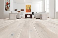 an empty living room with white furniture and wood flooring