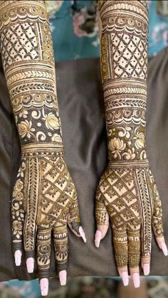 two hands with henna tattoos on them and one hand showing the intricate design in gold