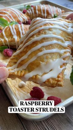 raspberry toaster strudels with white icing on them and fresh raspberries