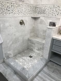 a walk in shower sitting next to a white counter top under a faucet