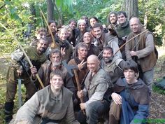 a group of men in medieval clothing posing for a photo with axes and shields on their shoulders