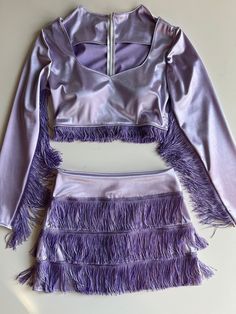 The space cowgirl skirt set includes a long sleeve cropped blouse and mini skirt. The crop top features breast cups and a back zipper. This design is made to order and can be customized by color and size. The pictured look is a lavender satin stretch with purple glitter fringe trim. Both the fringe and fabric can be customized. Measurements needed: Bust Waist Armpit to Wrist Hi Waist Hips Belly Button to desired skirt hem Space Cowgirl Theme Outfit, Purple Space Cowgirl, Purple Glitter Outfit, Purple Western Outfit, Osheaga Outfits, Sparkly Cowgirl Outfit, Space Cowgirl Outfits, Space Cowgirl Theme, Cowgirl Costume Diy