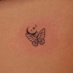 a small butterfly tattoo on the back of a woman's left side ribcage