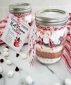 two mason jars filled with marshmallows and chocolate