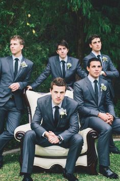 a group of men in suits sitting on top of a couch