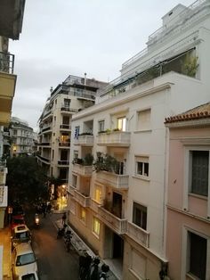 an apartment building with balconies and cars parked on the street