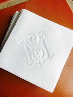 two white napkins sitting on top of a table next to an orange countertop