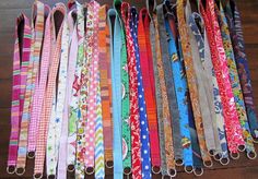 many different colored lanyards are lined up on the floor with each one's own ribbon