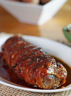 a white plate topped with meat covered in sauce