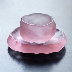 two pink dishes sitting on top of each other