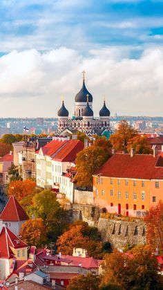 an aerial view of the city with many buildings and trees in autumn colors, including red roofs