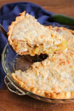 a close up of a pie on a plate with a fork in it and a blue cloth