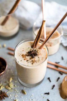 two glasses filled with different types of food and cinnamon sticks sticking out of the top