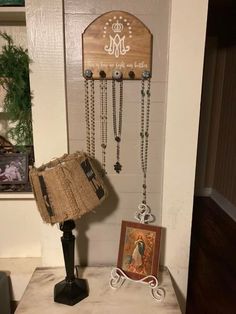 a wooden sign hanging from the side of a wall next to a lamp and pictures