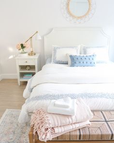 a white bed with pillows and blankets on it