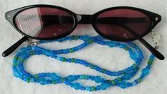 You'll always know where your eyeglasses are when you use this light blue beaded eyeglass chain! 26.5" in length, made with glass beads, beading cord, metal lobster clasps, and adjustable rubber holders. Lobster clasps make it easy to change the rubber holders, and an extra pair of holders included with every purchase. This light blue beaded eyeglass chain will arrive in a gift box, ready to give as a present or to keep and store. Back to Beaded Eyeglass Chains Blue Beaded Chain Glasses Chains With Round Beads, Blue Beaded Glasses Chains, Blue Glasses Chains With Round Beaded Chain, Blue Beaded Glass Glasses Chains, Adjustable Blue Glasses Chains With Colorful Beads, Handmade Adjustable Blue Glasses Chains, Blue Glasses Chains With Colorful Beads For Beach, Blue Glasses Chains With Colorful Beads For Gift, Blue Glasses Chain With Colorful Beads For Gift