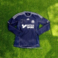 a soccer jersey laying on the grass with an inter sport logo on it's chest