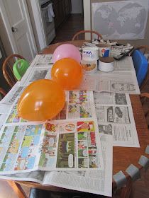 balloons and newspapers on a table in a kitchen