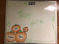 a white board with pumpkins on it and the words happy fall written in green