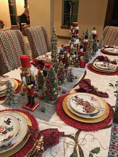 a table set for christmas with plates and napkins on it, decorated like trees