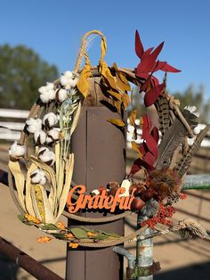 a sign that is on top of a pole with some flowers and leaves around it