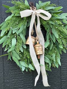 a christmas wreath with bells and greenery hanging on the front door to give it a festive touch