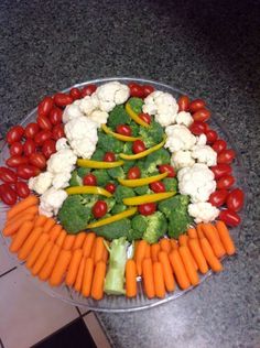 a platter filled with vegetables and veggies arranged in the shape of a christmas tree