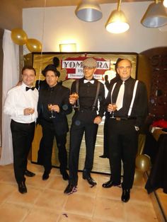 four men in tuxedos posing for a photo