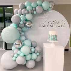 a cake and balloons are on display at a baby shower