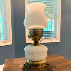 a white lamp sitting on top of a wooden table