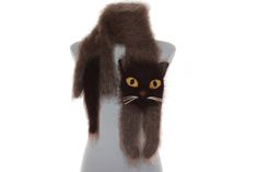 a black cat with long hair on top of a mannequin