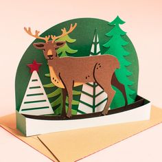 a card with an image of a deer standing in the middle of a christmas tree forest