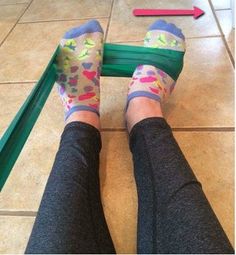 the legs of a person wearing colorful socks standing in front of a green frame with an arrow pointing to them