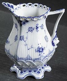 a blue and white pitcher sitting on top of a table