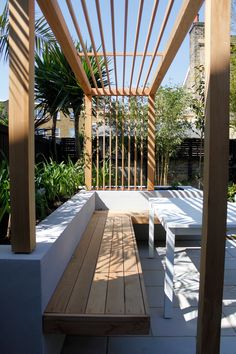 a wooden bench sitting under a pergolated roof