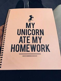 someone holding a notebook with the words my unicorn ate my homework