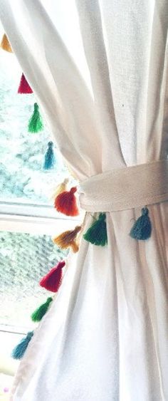 a curtain with tassels hanging from it's side in front of a window