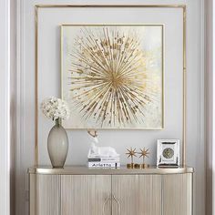 a white and gold sideboard in a living room next to a painting on the wall