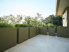 an outdoor patio area with stone walls and trees in the backgrouds behind it