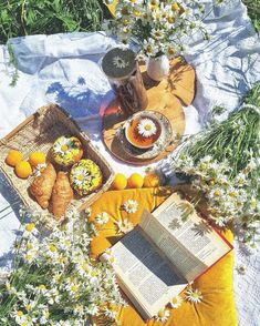 an open book sitting on top of a table next to flowers and other food items