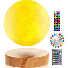 the moon lamp is on top of a wooden stand with remotes and other accessories