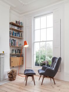 an image of a living room with chairs and bookshelves on the wall above